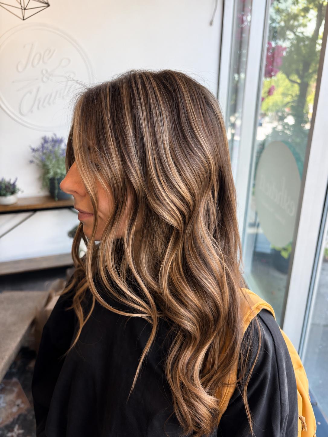 Client with dimensional balayage waves, profile view in the studio