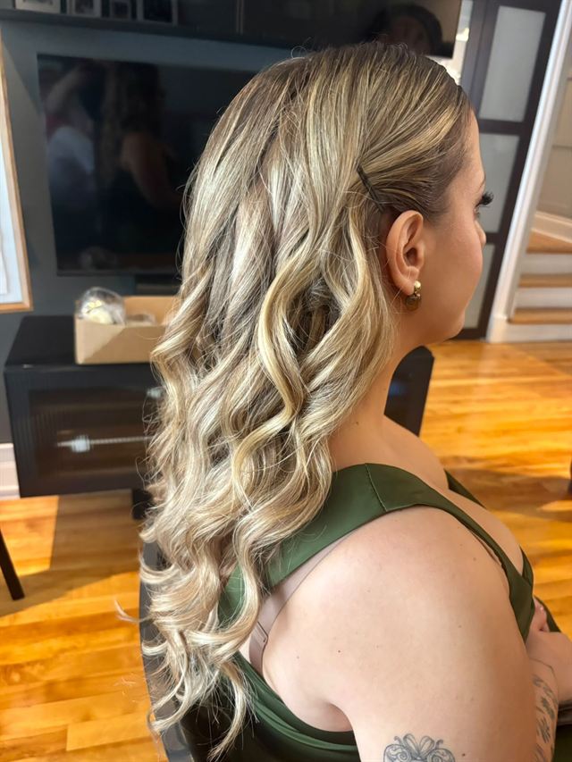 Blonde balayage in loose curls, pinned back on one side