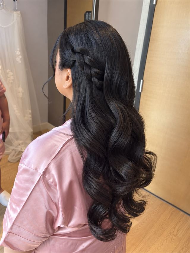 Long black hair, half-up with a side braid and glossy curls